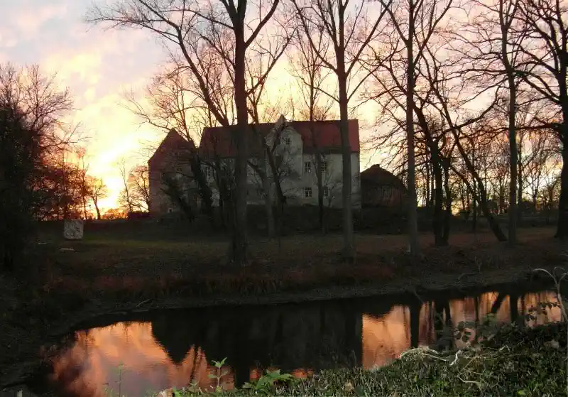 Burg im Abendlicht hinter dem Burggraben